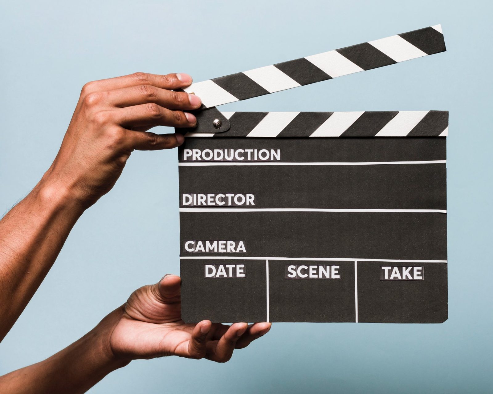Mains tenant un clap de cinéma